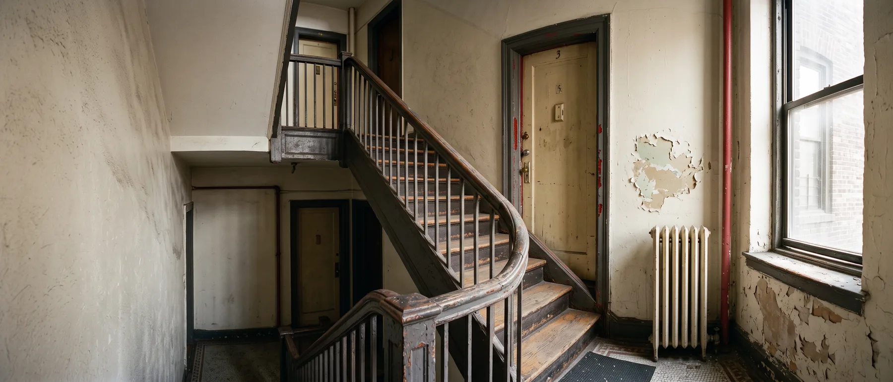 The painted stairwell of an older NYC walk-up, the kind of common area Local Law 1 lead paint rules cover